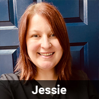 A person with shoulder-length reddish-brown hair, identified as Jessie, is smiling in front of a blue paneled door. They are wearing a dark-colored top. The name "Jessie" is displayed in white text on a black background at the bottom of the image, hinting at their dedication as a veterinarian.